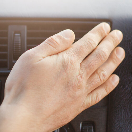 man's hand on a car heater vent