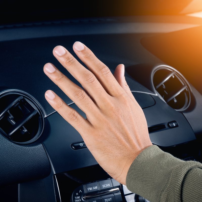 holding a hand up to a car AC vent